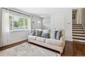 Bright living room with a comfortable sofa, patterned rug, and views of the front yard at 4502 S Gar Way, Littleton, CO 80123