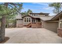 Charming two-story home with a well-manicured lawn and mature trees creating curb appeal at 1221 Havenwood Way, Castle Pines, CO 80108