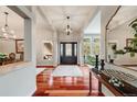 Elegant foyer with gleaming hardwood floors, chandelier, and views into the dining room at 1221 Havenwood Way, Castle Pines, CO 80108