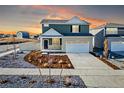 Two-story home with a two car garage and neutral colored landscaping at sunset at 3869 N Shawee St, Aurora, CO 80019