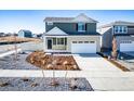Two-story home with a two car garage and neutral colored landscaping at 3869 N Shawee St, Aurora, CO 80019