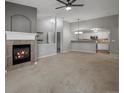 Open living room with fireplace, carpeted floors, and seamless flow into the kitchen at 7131 S Wenatchee Way # C, Aurora, CO 80016