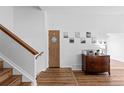 Entryway featuring wood-look floors, a classic wood dresser, and staircase to the left at 455 Saddlewood Cir, Highlands Ranch, CO 80126