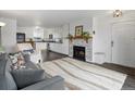 Cozy living room featuring a stone fireplace, plush rug, and an open view into the modern kitchen at 4226 S Eldridge St # 207, Morrison, CO 80465