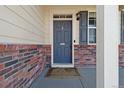 Welcoming front door with classic brick surround and stylish light fixture at 15507 Quince Cir, Thornton, CO 80602