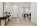 Bright foyer with beautiful wood floors, a console table with plant, and views into the home office at 16345 Milwaukee St, Thornton, CO 80602