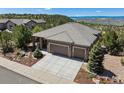 Charming exterior featuring a three-car garage, elegant stone accents, and professional landscaping at 438 Galaxy Dr, Castle Rock, CO 80108