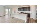 Well-lit open concept kitchen with stainless appliances and a kitchen island at 98 Wooten Ave, Brighton, CO 80601