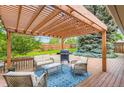 Relaxing outdoor patio with modern seating, a grill, and a wooden pergola at 2531 S Hoyt Ct, Lakewood, CO 80227