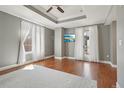 Cozy bedroom with tray ceiling, ceiling fan, TV, and natural light streaming in through sheer curtains at 1827 N Grant St # 502, Denver, CO 80203
