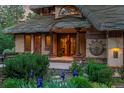 Inviting home entrance with a red front door, decorative columns, and meticulously maintained garden with blue irises at 4406 Orofino Pl, Castle Rock, CO 80108