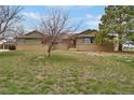Ranch-style home with brick and green siding, set on a spacious grassy lot under a blue sky at 12337 2Nd St, Parker, CO 80134