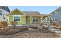 Inviting home showcasing a covered front porch, green and white color palette, plus a well-maintained landscape at 2838 Cascade Creek Dr, Lafayette, CO 80026