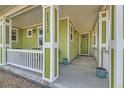 Covered porch shows painted columns, house number, seating area, and entry door at 2838 Cascade Creek Dr, Lafayette, CO 80026