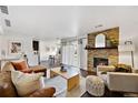 Bright living room featuring stone fireplace, stylish furniture, and a walkout patio at 7346 S Xenia Cir # A, Centennial, CO 80112