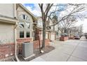 Charming townhome with brick accents, an attached garage, mature trees and a well-maintained front yard at 5243 Union Ct # 4, Arvada, CO 80002