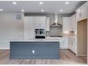Bright kitchen with white cabinetry, modern appliances, and a central island with light countertops at 8581 Eckley St, Littleton, CO 80125