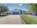 Inviting home showcasing a well-maintained lawn and a two-car garage at 11560 River Run Cir, Commerce City, CO 80640