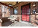 Inviting front porch with a wooden swing and red door at 3311 W Clyde Pl, Denver, CO 80211