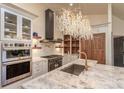 Bright kitchen with stainless steel appliances, chandeliers, and sink at 93 Glenmoor Dr, Englewood, CO 80113