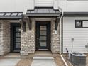 Stylish front door with stone surround, black trim, and modern hardware, providing a welcoming entrance to the home at 2046 S Holly St # 1, Denver, CO 80222
