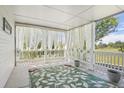 Inviting covered porch featuring breezy curtains and a decorative rug, perfect for relaxing outdoors at 10711 Longs Way, Parker, CO 80138