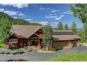 Expansive view of craftsman-style home, showcasing the roof, solar panels, and surrounding landscape at 31189 Manitoba Dr, Evergreen, CO 80439