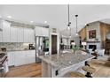 Bright, updated kitchen featuring a large granite island, stainless steel appliances, and hardwood floors at 31189 Manitoba Dr, Evergreen, CO 80439