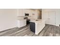 Clean, modern kitchen featuring white cabinets, stainless steel appliances, a kitchen island and quartz countertops at 1224 S Algonquian St, Aurora, CO 80018