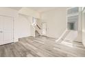 Bright living room with modern gray wood floors, white walls, and natural light entering from multiple windows at 1224 S Algonquian St, Aurora, CO 80018