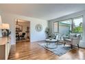 Bright living room with hardwood floors, large window, and stylish furnishings at 4114 S Niagara Way, Denver, CO 80237