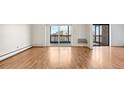 Bright living room featuring hardwood floors, large sliding glass doors, and a balcony, providing ample natural light at 13601 E Marina Dr # 604, Aurora, CO 80014