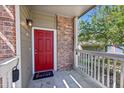 Inviting front porch with red door and brick accents, creating a welcoming entrance to the residence at 16366 E Fremont Ave # 3, Aurora, CO 80016