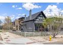 Gray two-story home with a fence, lovely landscaping, and a charming outdoor patio area at 2135 W 40Th Ave, Denver, CO 80211