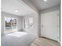 A bright living room featuring light hardwood flooring and a sliding glass door at 46566 Avery Ln, Bennett, CO 80102