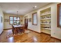 Bright dining room with hardwood floors, built-in shelving, and large windows at 6800 Saddleback Ave, Firestone, CO 80504