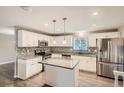Updated kitchen with stainless steel appliances and an island at 9014 W Harvard Dr, Lakewood, CO 80227