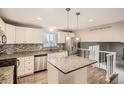 Well-lit kitchen with stainless steel appliances, granite countertops, and modern fixtures at 9014 W Harvard Dr, Lakewood, CO 80227