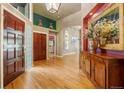 Inviting foyer features hardwood floors, an elegant chandelier, and views of the dining area and sitting room at 474 Silbrico Way, Castle Rock, CO 80108