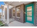 Inviting front porch with brick details, colorful front door, and xeriscaping for a low-maintenance appeal at 888 S Valentia St # 103, Denver, CO 80247