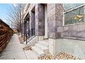 Close-up of townhome entry featuring stone accents, concrete steps, and modern railings at 2622 W 24Th Ave # 4, Denver, CO 80211