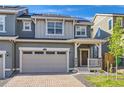Charming two-story home with a brick driveway, garage, and covered porch, perfect for enjoying the outdoors at 645 Flintwood Pl, Lafayette, CO 80026
