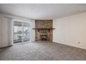 Cozy living room with a stone fireplace and sliding glass doors opening to an outdoor space at 13241 E Asbury Dr # 203, Aurora, CO 80014