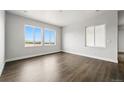 Sunlit bedroom with large windows and hardwood floors, showcasing an inviting and airy atmosphere at 17125 W 92Nd Loop, Arvada, CO 80007
