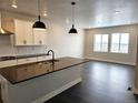 Open-concept kitchen with a central island, dark countertops, stainless steel appliances and hardwood floors at 17125 W 92Nd Loop, Arvada, CO 80007