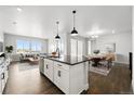 Spacious open concept living area with a modern kitchen island, dining area, and bright living room at 17125 W 92Nd Loop, Arvada, CO 80007