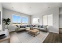 Bright and airy living room featuring a comfortable sofa, modern coffee table, and large windows at 17125 W 92Nd Loop, Arvada, CO 80007
