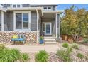 Inviting home with stone accents, a charming entrance, and a well-manicured lawn at 9921 W Edenburg Pl, Littleton, CO 80127