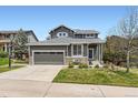 Inviting home with stone accents, a well-manicured lawn, and a two-car garage at 9921 W Edenburg Pl, Littleton, CO 80127
