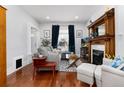 Cozy living room features a fireplace, wood floors, large windows, and comfortable seating at 613 S Logan St, Denver, CO 80209